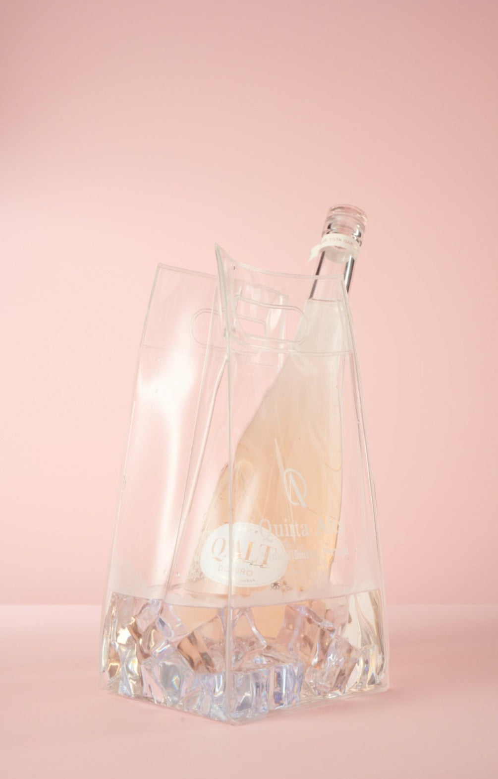 Qalt Rosé in durchsichtiger Handtasche auf Pinkem Hintergrund