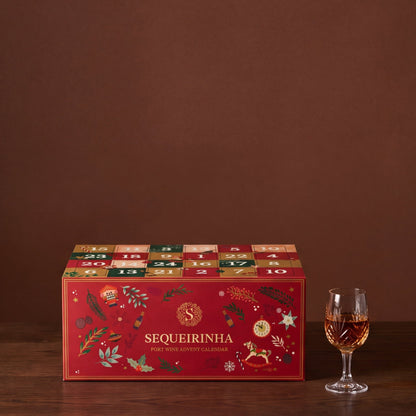 Portwein-Adventskalender mit einem Glas Tawny auf dem Holztisch